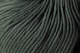 Close-up of dark green Jo Sharp Soho Summer DK Cotton yarn from Kingfisher Yarn & Fibre, showcasing its soft texture and tightly woven strands. The lightweight cotton fibers run horizontally in wavy, parallel lines, capturing the intricate details of this summer yarn.