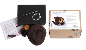 Image of the Ashford Needle Felting Kit for creating a felt seal. The kit includes brown, black, and orange wool, a felting needle, needle felting instructions, a foam block, and an image of the finished seal on the packaging. The box is labeled "Ashford Needle Felting Kit" by Ashford Handicrafts Limited.