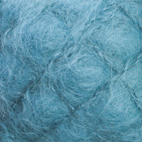 A close-up image of teal-colored strands from the Victorian Brushed Mohair Yarn by Caledonian Dye Works, intricately interwoven to create a soft and fluffy texture. The fibers, echoing the luxurious quality of mohair, exhibit a gently wavy pattern with varying shades of teal that add depth to the image.