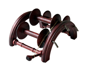 The Kromski Lazy Kate Arch by Kromski North America is an antique-style wooden bobbin holder featuring four vertical rods that hold multiple spools of thread. It has a curved upper part, is dark brown in color, and provides excellent tension control. Some bobbins have twine wrapped around them.