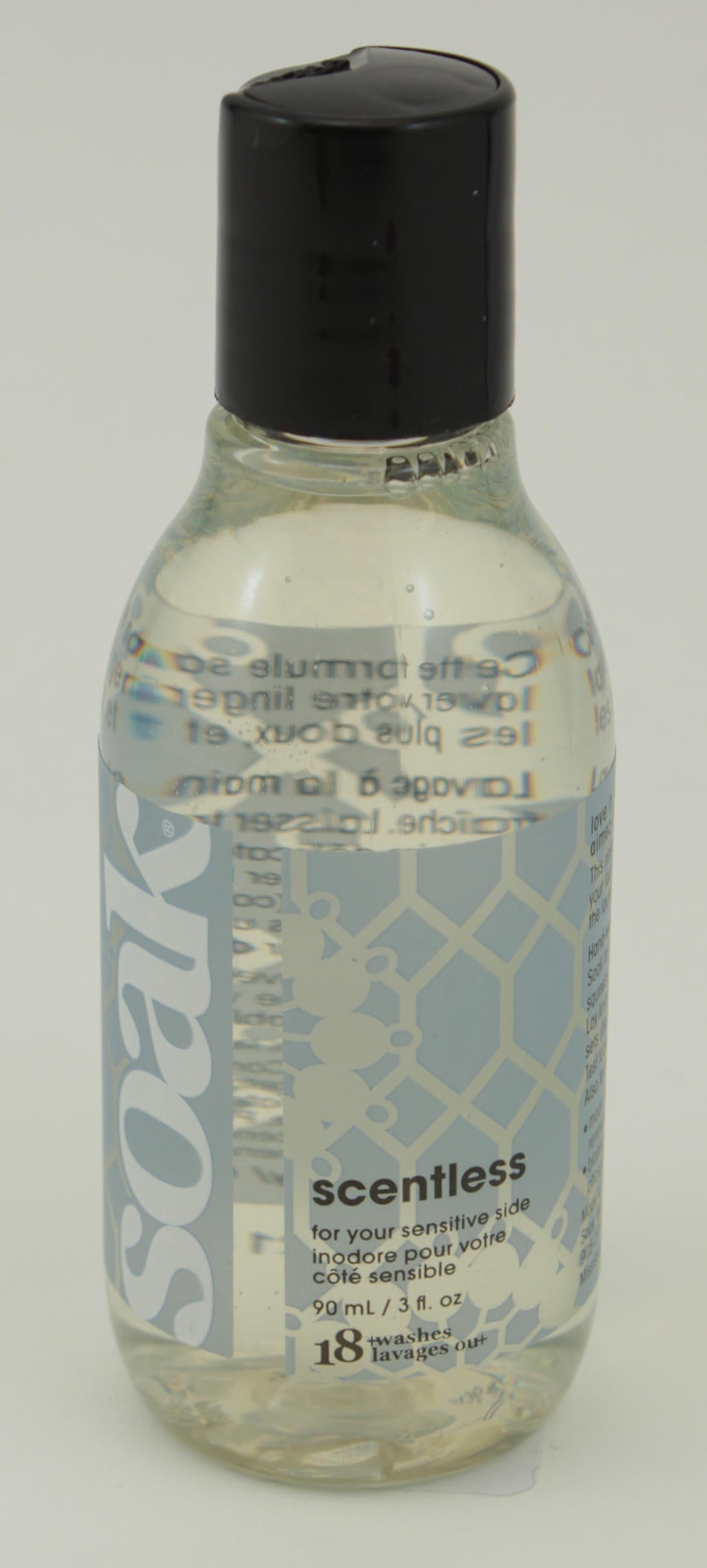 A small, clear plastic bottle with a black cap, labeled "Soak Wash" on the left in large white letters. The label describes this biodegradable product from Soak Wash Inc. as scentless and suitable for sensitive skin, providing directions for its use as a delicate wash along with volume information (90ml/3 fl. oz).