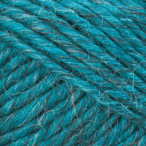 Close-up image of Lamb's Pride Worsted Yarn by Brown Sheep in turquoise. The texture reveals strands twisted together with visible fibers, creating a fluffy and slightly fuzzy appearance. Ideal for Brown Sheep's Lamb's Pride Worsted or felting projects, the yarn features subtle variations in the shade of turquoise that add depth to its color.