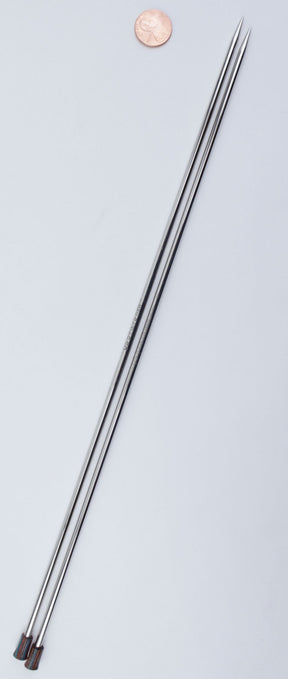 Two long, smooth, and shiny skewers with pointed tips are placed side by side on a light surface. There is a penny at the top for scale. Resembling the sleek design of Accessories Unlimited's Nova Platina Single Point Knitting Needles, they feature small black handles on one end and appear almost like hollow brass pipes.