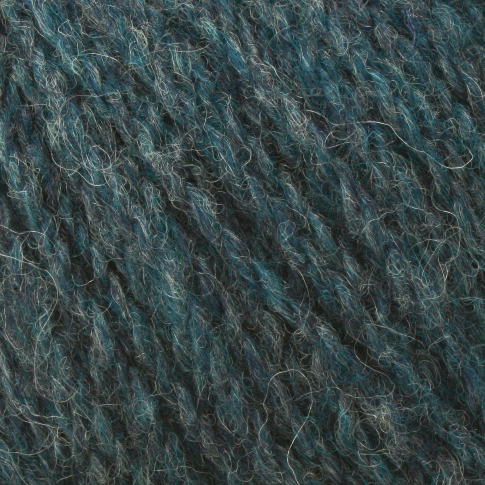 A close-up image of a textured fabric made from Bartlettyarns Maine Wool Yarn, featuring a blend of dark blue and teal fibers. The strands are interwoven to create a slightly fuzzy appearance, giving the worsted weight yarn a soft and cozy look that perfectly showcases its heathered colors.