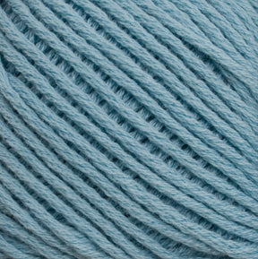 Close-up image of Brown Sheep's Cotton Fleece yarn in light blue, expertly wound into a tight, orderly coil. The fibrous texture and intertwined strands are clearly visible, highlighting the softness and uniformity of the yarn—ideal for creating intricate knitting patterns.