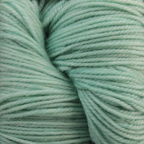 Close-up of soft, light green Malabrigo Sock yarn fibers tightly wound together from Malabrigo Yarn, creating a textured and detailed view. The yarn appears fluffy and smooth, with gentle shadows highlighting its twists and turns. This machine washable yarn ensures ease of care without compromising on its delicate beauty.