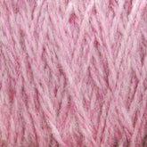 Close-up of soft, pink yarn strands intertwined. The image showcases the detailed texture and fibrous nature of Harrisville Designs' Harrisville Highland - Cones yarn, highlighting its fuzzy and slightly fluffy appearance. The thick, unscoured yarn appears tightly knit with visible spinning oils.