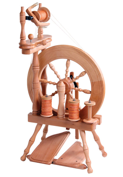 Introducing the Ashford Traveller Spinning Wheel, Double-Treadle by Ashford Handicrafts Limited – a traditional wooden spinning wheel designed for ease of travel. It features a large wheel on the right, smaller bobbins, a spindle, and dual foot pedals. This light and compact castle-style wheel is perfect for spinning on the go and includes a built-in lazy kate. The wood boasts a light, natural finish that beautifully highlights its intricate craftsmanship.