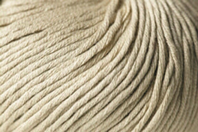 Close-up image of a beige Jo Sharp Soho Summer DK Cotton yarn ball from Kingfisher Yarn & Fibre, displaying the tightly wound strands of fiber. The texture appears soft and smooth, with the strands neatly arranged in parallel lines. The image captures the intricate details of this summer yarn’s composition.