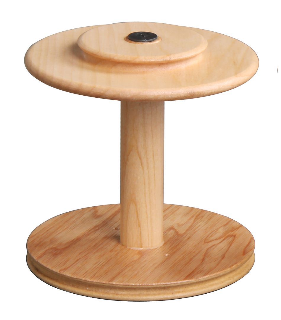 The Ashford Jumbo Bobbin by Ashford Handicrafts Limited is a wooden display stand with a circular top and base, designed for showcasing items. The natural wood finish gives it a rustic look, and it features a central supporting column connecting the top and base.