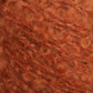 Close-up image of fuzzy, orange Victorian Bouclé Mohair Yarn with a slightly curly and fluffy texture from Caledonian Dye Works' Signature Victorian Collection, showcasing the intricate details of the fibers.