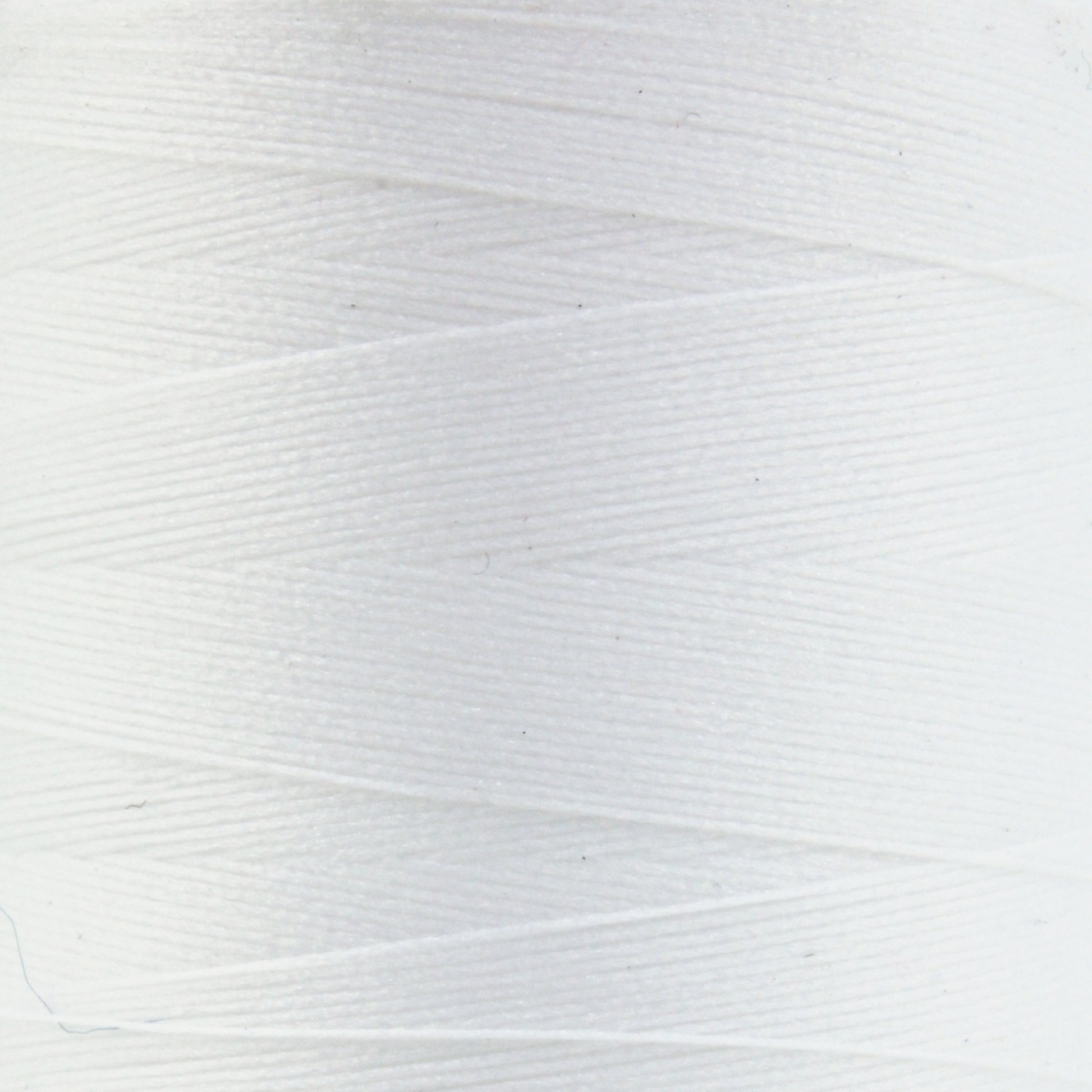 A close-up view of a white spool of Woolly Nylon Reinforcement Yarn by YLI Corp. The tightly wound yarn showcases a smooth, even texture with subtle linear patterns created by the overlapping strands. The image highlights the clean, crisp appearance of the yarn, often used for enhancing the durability of socks.