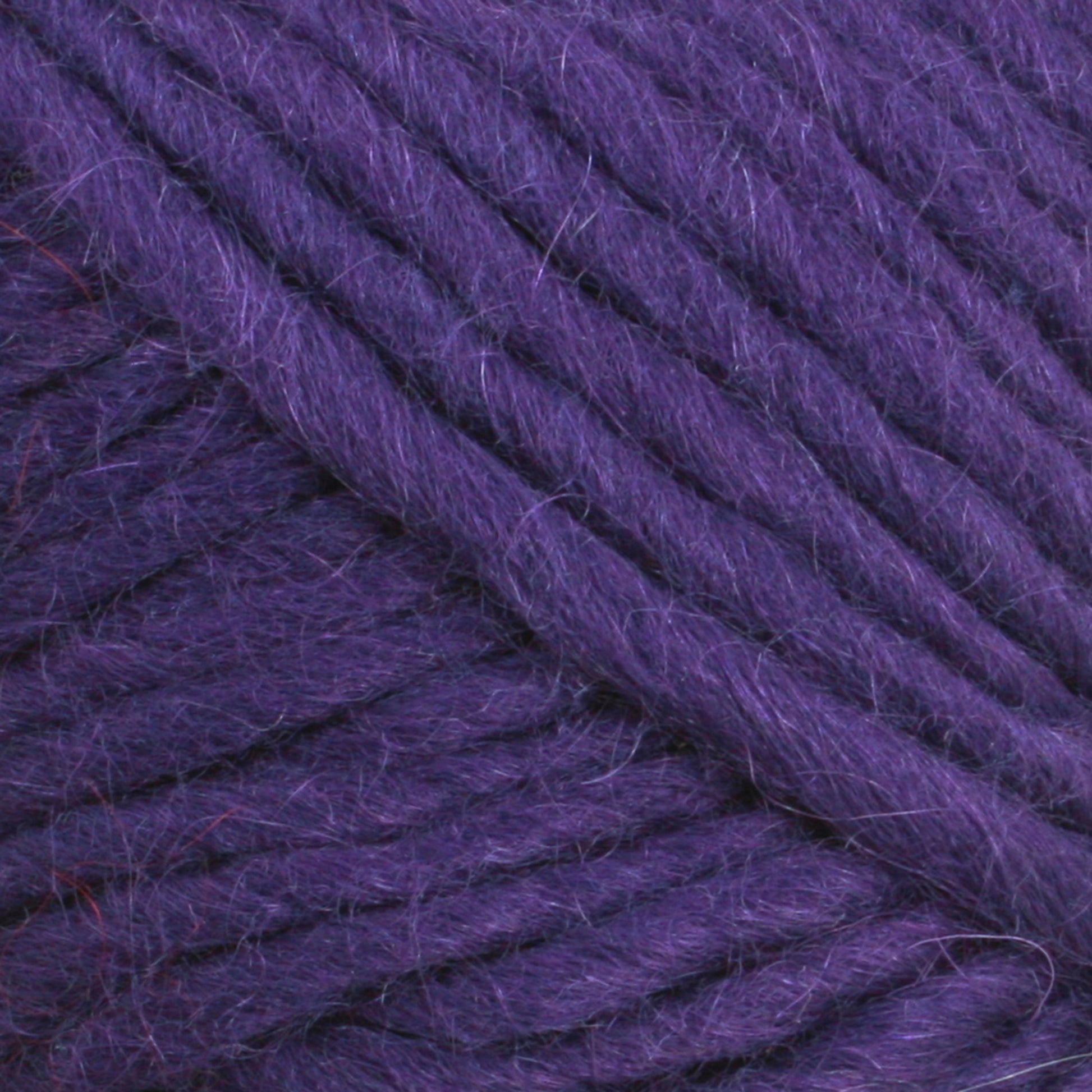 Close-up of thick, purple yarn with a slightly fuzzy texture. The strands of Lamb's Pride Worsted Yarn from Brown Sheep are tightly wound, showcasing their rich color and soft fibers—ideal for Navajo style weaving. The image emphasizes the intricacies of the yarn's texture and the detail in its individual threads.