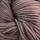 Close-up image of tightly coiled, soft Malabrigo Arroyo sport weight superwash merino wool yarn by Malabrigo Yarn in shades of light brown and taupe, showcasing the texture and natural variances in color fibers—perfect for lightweight garments.