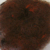 A tightly wound ball of dark, mixed-color hair or fur sits against a plain white background. The tangle has shades of brown, black, and hints of red mixed throughout, reminiscent of Harrisville Designs' Harrisville Dyed & Carded Wool Fiber with its heathered colors.