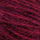 A close-up image of red and purple mixed Harrisville Shetland Yarn - Unwashed Cones by Harrisville Designs, revealing its thick, braided texture. The strands are tightly wound together, creating a warm and cozy appearance suitable for Fair Isle knitting designs or crocheting projects.