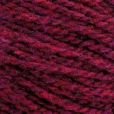 A close-up image of red and purple mixed Harrisville Shetland Yarn - Unwashed Cones by Harrisville Designs, revealing its thick, braided texture. The strands are tightly wound together, creating a warm and cozy appearance suitable for Fair Isle knitting designs or crocheting projects.