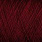 Close-up image of dark red JaggerSpun Maine Line 2/20 Yarn wound into a ball. The fibers crisscross each other, creating a textured, intricate pattern. The rich hue of the Jagger Brothers, Inc. yarn stands out, highlighting the fine details and soft appearance of the medium-grade wool.