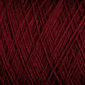 Close-up image of dark red JaggerSpun Maine Line 2/20 Yarn wound into a ball. The fibers crisscross each other, creating a textured, intricate pattern. The rich hue of the Jagger Brothers, Inc. yarn stands out, highlighting the fine details and soft appearance of the medium-grade wool.