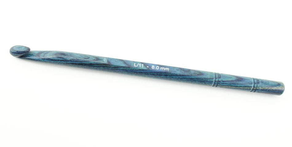 A handcrafted wooden crochet hook in blue and green, marked with size "L/11 - 8.0 mm" etched near the center, this hook from the Accessories Unlimited Knitter's Pride Symfonie Dreamz collection boasts a smooth, tapered design with decorative grooved accents at both ends—an exquisite symfonie wood crochet hook.