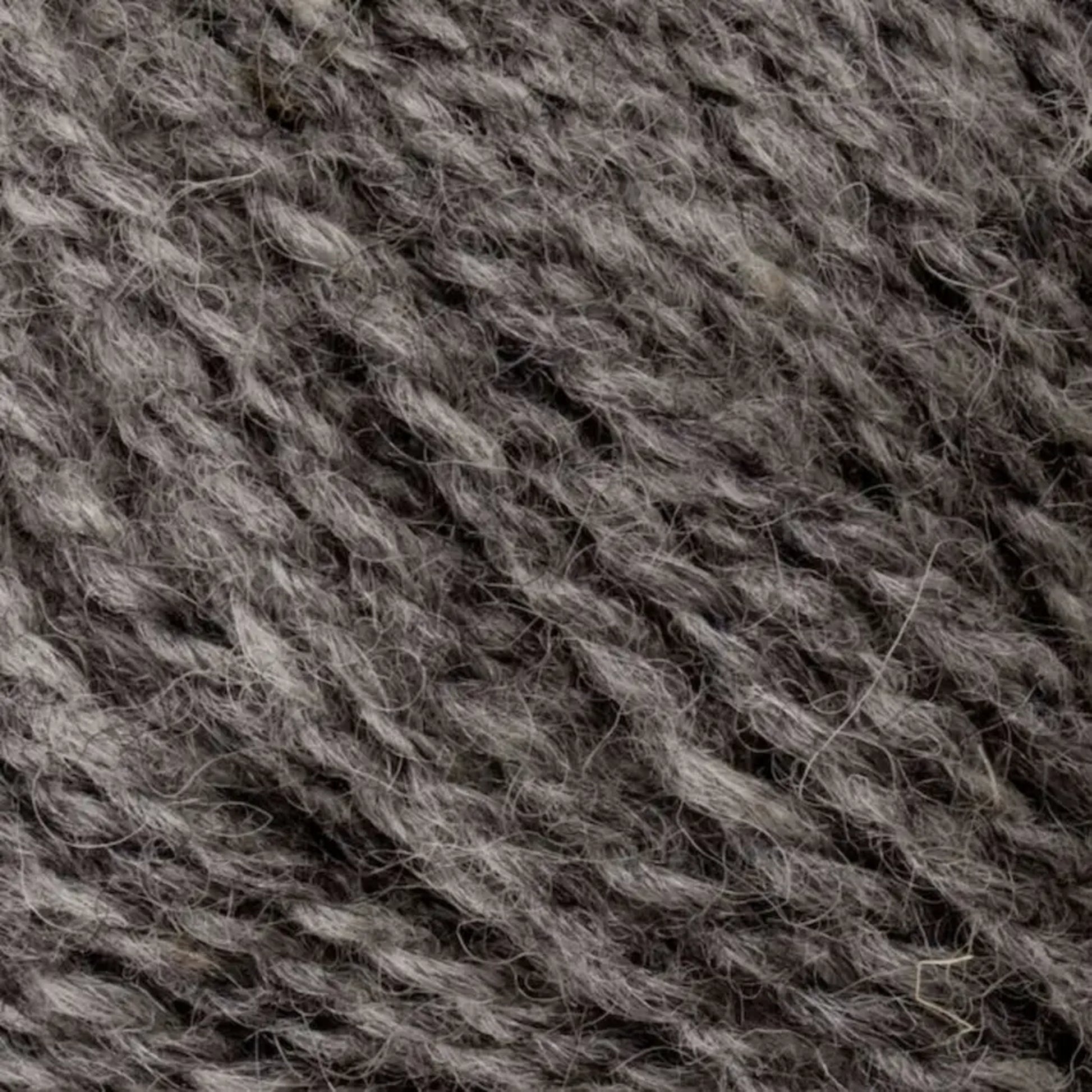 Close-up of Bartletts Maine Wool - Sport, showcasing a detailed texture with intertwined gray yarn fibers. The wool appears slightly fuzzy, with a soft, woolly appearance that is ideal for knitting or crocheting projects.