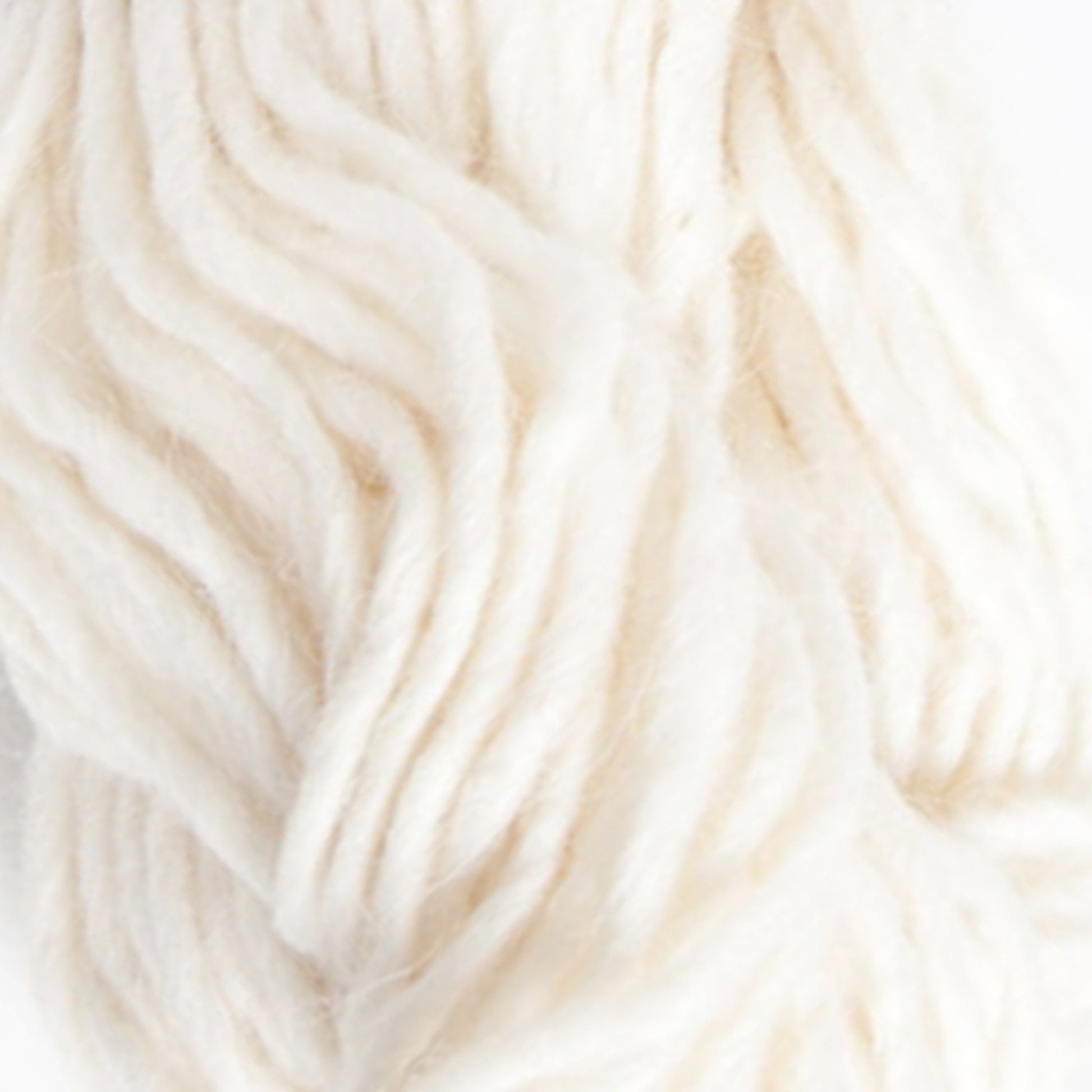 Close-up image of Jöklalopi (Bulky Lopi) off-white wool yarn by Berroco, Inc. The fibers appear soft, loosely twisted, and slightly fluffy, creating a cozy texture. The natural color and rustic handmade charm suggest the yarn is suitable for knitting or crocheting chunky winter sweaters and accessories.