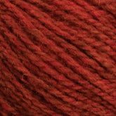 Close-up image of Harrisville Shetland Yarn - Unwashed Cones by Harrisville Designs in a deep red, slightly marled hue. The fibers appear soft and fluffy with a slight twist, suggesting it might be wool or a wool blend, ideal for knitting Fair Isle designs or lightweight blankets.