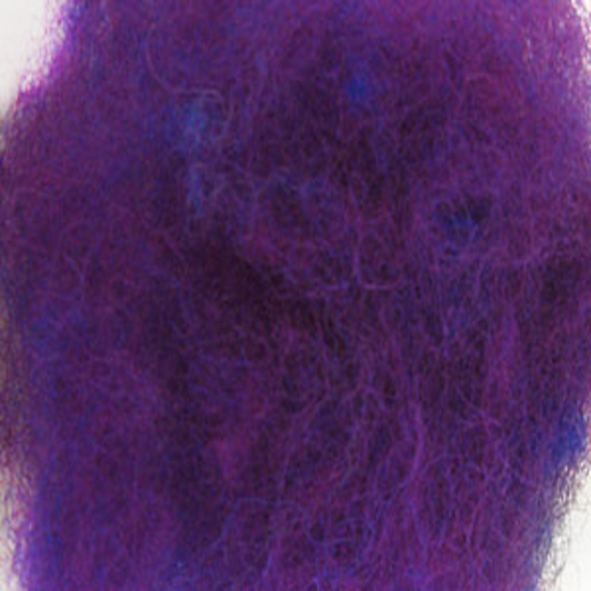 A dense clump of fuzzy, purple fibers with a few hints of blue scattered throughout resembles Harrisville Dyed & Carded Wool Fiber from Harrisville Designs. The heathered colors create a rich, textured, tangled appearance against a white background.