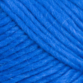 Close-up image of Brown Sheep's Lamb's Pride Bulky Yarn in blue, highlighting the texture and twist of the fibers. The strands are thick and tightly coiled, creating a soft, fluffy appearance ideal for woven blankets or projects by knitters and crocheters.