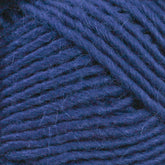 Close-up of a bundle of Lamb's Pride Worsted Yarn by Brown Sheep in blue. The fibers are tightly wound together, showcasing their texture and thickness. The rich, deep blue color is consistent throughout the strands, making it perfect for Navajo style weaving or felting projects.