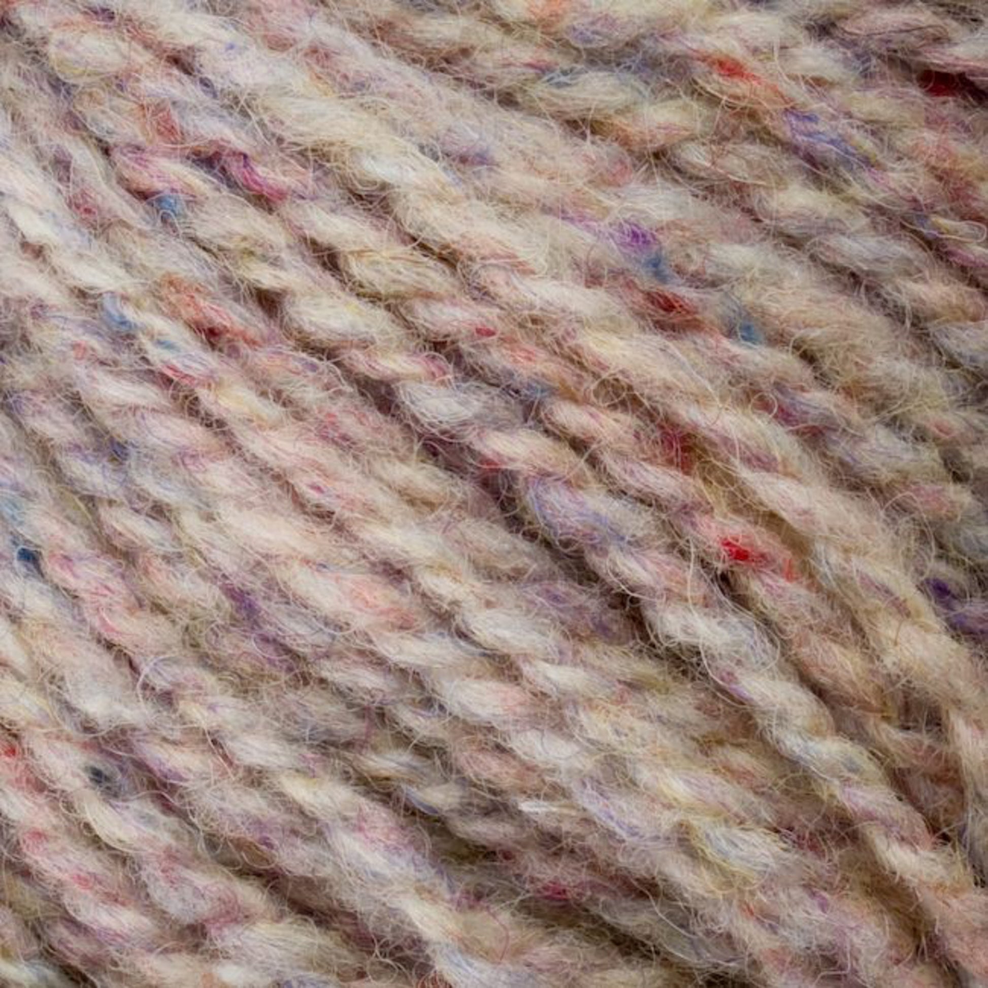 Close-up image of beige Bartlettyarns' Bartletts Maine Wool - Sport yarn, featuring multicolored flecks in shades of pink, blue, and purple. The texture appears soft and slightly fuzzy with tightly twisted strands. The colors are subtly blended, creating a speckled effect throughout this sport weight yarn.