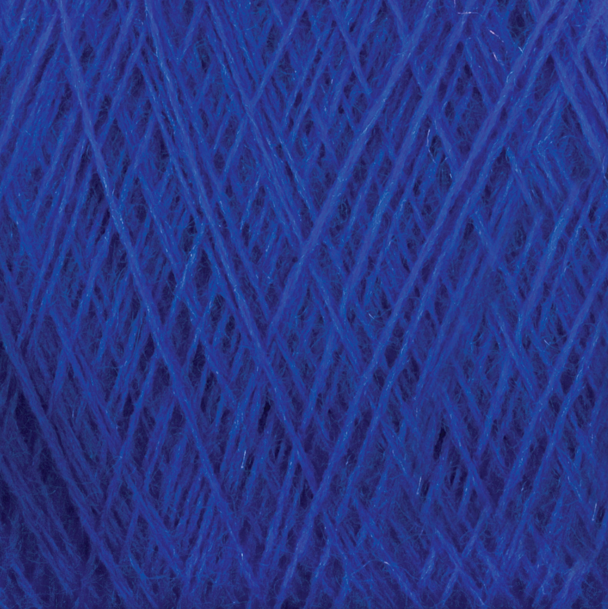 Close-up image of a ball of JaggerSpun Maine Line 2/20 Yarn from Jagger Brothers, Inc., showcasing the texture and intricate crisscrossing pattern of the fibers. The medium grade wool appears soft and fluffy, with various shades of blue creating depth.