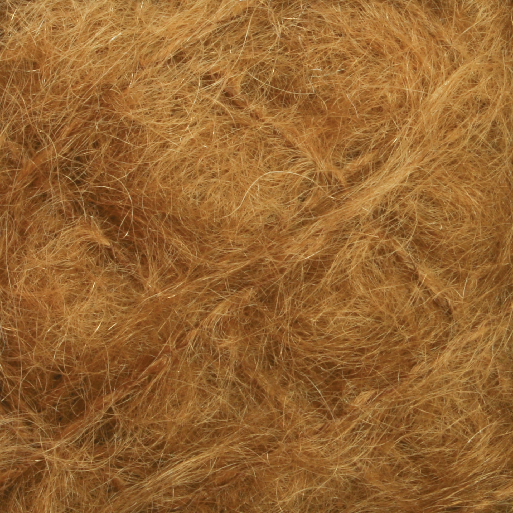 A close-up image of a mass of tangled, brown fibers. The strands are thin and curly, densely packed together, creating a textured, fuzzy appearance reminiscent of luxurious Victorian Brushed Mohair Yarn from Caledonian Dye Works. The overall color is a warm, golden-brown shade.