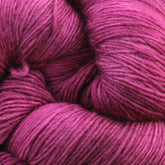 Close-up image of a large bundle of magenta-colored Malabrigo Lace yarn by Malabrigo Yarn, with its fibers and strands clearly visible, showcasing texture and detail—perfect for crafting intricate knitted shawls.