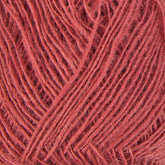 Close-up of a ball of coral-colored Einband Lopi yarn by Berroco, Inc. The yarn strands are neatly wound, creating a textured pattern. The threads appear soft and slightly fuzzy, indicative of a natural fiber perfect for stranded colorwork.