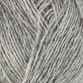 Close-up image of a ball of gray Einband Lopi yarn, crafted from Icelandic wool by Berroco, Inc. The fibers appear textured and slightly varied in thickness, creating a soft and cozy look. The image emphasizes the intricate details and strands of the yarn, perfect for stranded colorwork projects.