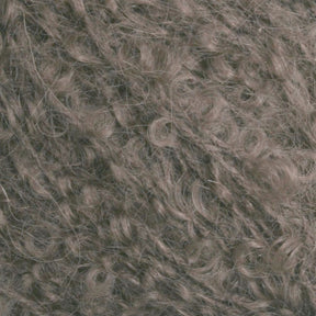 A close-up of the Victorian Bouclé Mohair Yarn from Caledonian Dye Works. The grey fibers have a texture that appears soft and dense, with tight curls interwoven throughout the image. Evoking the essence of Halcyon's Signature Victorian Collection, the mix of light and dark grey tones gives it a natural, woolly appearance reminiscent of mohair bouclé.