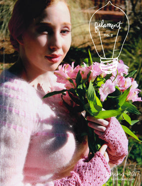 A person in a pink sweater and fingerless gloves holds a bouquet of pink flowers against a backdrop of green foliage. At the top, the text "Filament No. 2" accompanied by a light bulb illustration highlights modern classics, with "Spring 2017" and Knit Filament's web address at the bottom right.