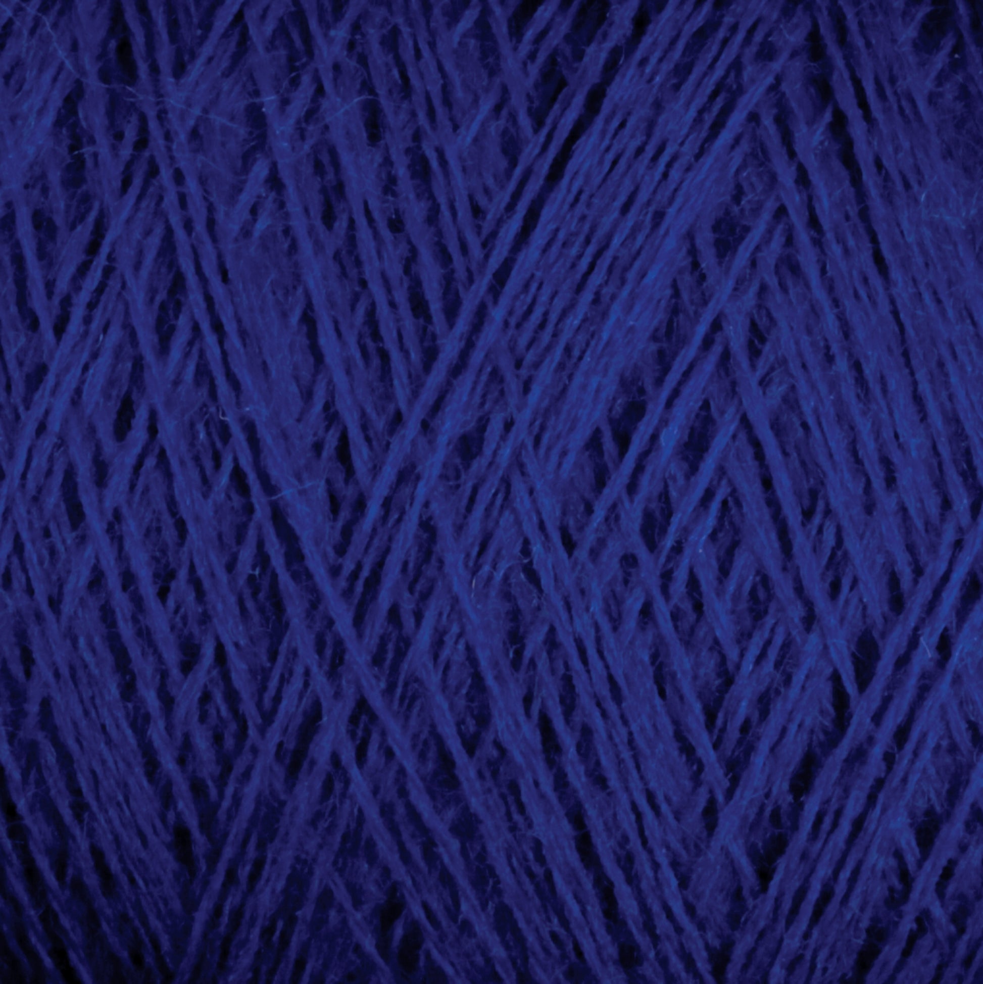 Close-up image of dark blue JaggerSpun Maine Line 2/20 Yarn on a large cone by Jagger Brothers, Inc., showcasing the intricate and tightly wound fibers and strands, creating a detailed texture. The overall appearance is rich and deep in color with a complex interweaving of threads.