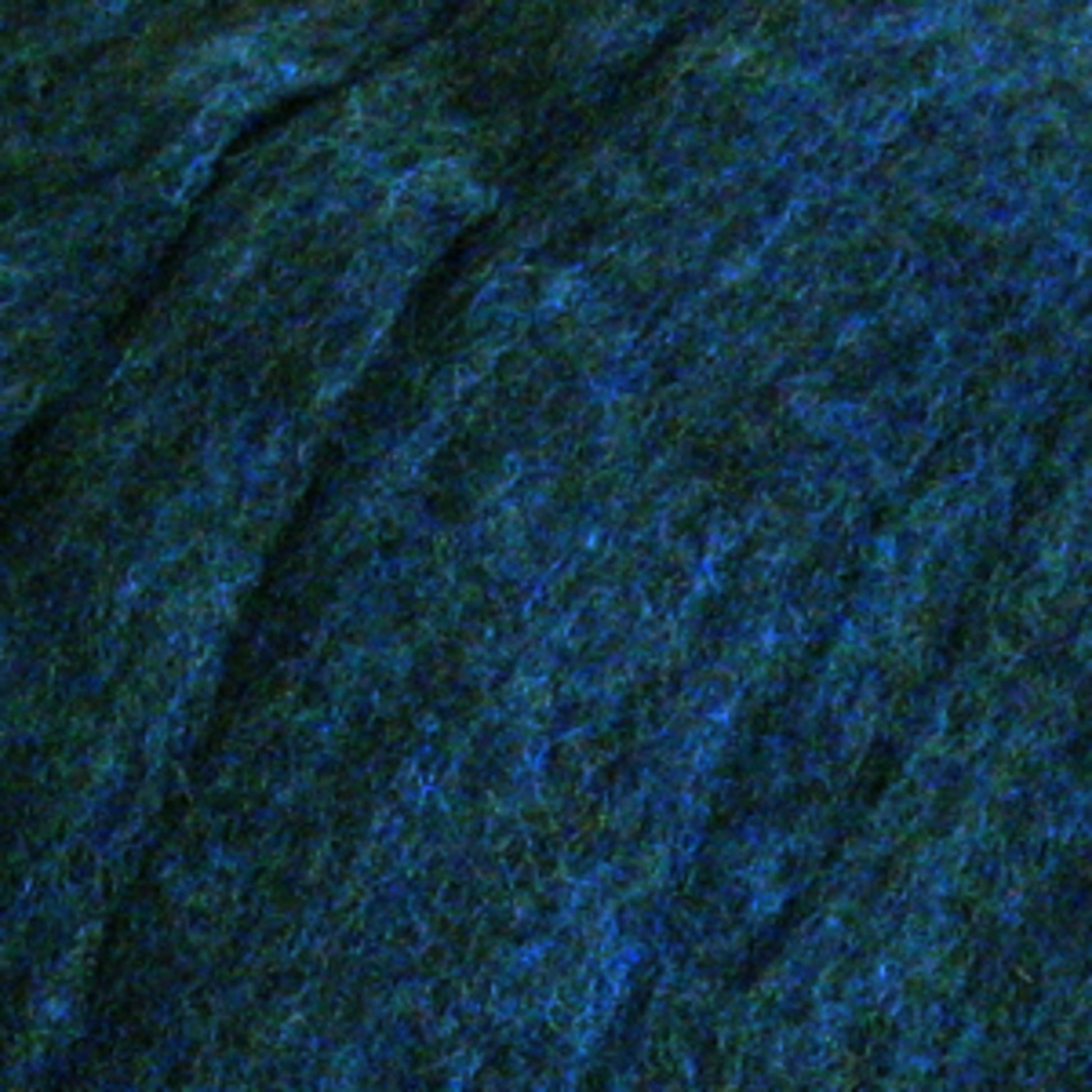 Close-up image showcasing a textured surface featuring a blend of dark navy blue and lighter heathered colors intertwined. The material, reminiscent of Harrisville Dyed & Carded Wool Fiber from Harrisville Designs, has a slightly rough, matted appearance similar to felt or felting wool.