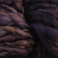 Close-up of thick, chunky super bulky Malabrigo Caracol yarn in shades of deep purple and brown from Malabrigo Yarn. The kettle-dyed superfine merino wool fibers appear soft and slightly twisted, exhibiting a rich, textured appearance.