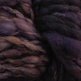 Close-up of thick, chunky super bulky Malabrigo Caracol yarn in shades of deep purple and brown from Malabrigo Yarn. The kettle-dyed superfine merino wool fibers appear soft and slightly twisted, exhibiting a rich, textured appearance.