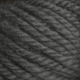 Close-up image of Halcyon Yarn Classic Rug Wool | Skein by Caledonian Dye Works. The thick, dark gray yarn features a slightly fuzzy texture and is tightly twisted in plies. The fibers appear soft and well-defined, making it ideal for knitting or crocheting projects. Perfect for weavers looking to incorporate this high-quality rug wool into their hand-dye creations.