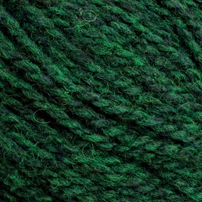 Close-up image of green Harrisville Highland - Cones yarn by Harrisville Designs, highlighting the intricate and twisted fibers. The various shades of green give the unscoured yarn a textured and slightly variegated appearance, with subtle hints of spinning oils adding depth.