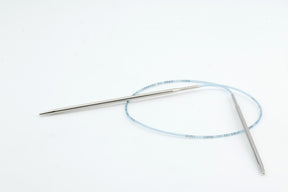 A pair of smooth, pointed Skacel Addi Turbo Circular Knitting Needles, connected by a flexible blue plastic cable, lie on a plain white background. Ideal for knitting projects like cuffs, collars, and doll clothes.