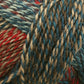 Close-up image of the Zauberball Crazy Sock Yarn by Skacel, showcasing a beautiful intertwining mix of reds, blues, and beige hues. The yarn texture appears soft and woolly, with dynamic color changes blending in a variegated pattern that creates a visually rich and textured appearance.