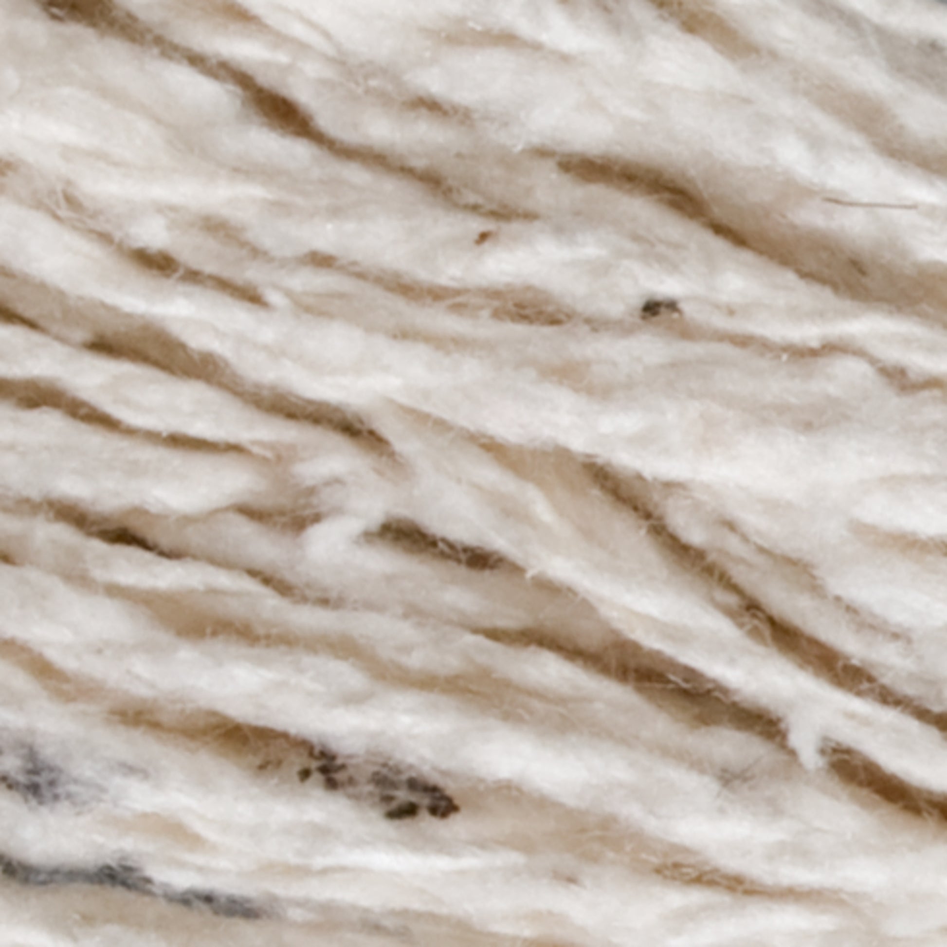 Close-up image of Henry's Attic 2-Ply Silk Noil Yarn (Raw Silk) large cone. It features a soft texture with intertwined strands of beige, brown, and white fibers, creating a variegated pattern ideal for weaving.