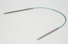 A pair of Skacel Addi Turbo Circular Knitting Needles with metal tips connected by a flexible blue cable are displayed against a plain white background. The slightly curved cable forms an open loop, ideal for knitting projects like cuffs, collars, and doll clothes.