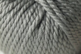 A close-up of tightly wound, thick, gray Jo Sharp Silkroad Ultra yarn. The fibers from Kingfisher Yarn & Fibre are neatly twisted together, forming a textured, braided pattern. The image highlights the chunky cuddly yarn's softness and dense weave—perfect for cozy winter accessories.