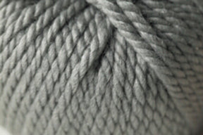 A close-up of tightly wound, thick, gray Jo Sharp Silkroad Ultra yarn. The fibers from Kingfisher Yarn & Fibre are neatly twisted together, forming a textured, braided pattern. The image highlights the chunky cuddly yarn's softness and dense weave—perfect for cozy winter accessories.